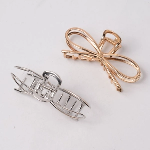 Detail of elegant gold and silver metal bow hair claws with polished glossy finish