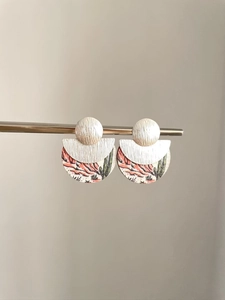 Détail de boucles d'oreilles rondes bohèmes avec disque argenté et décor de désert