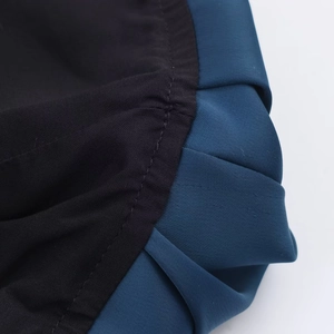 Detailed close-up showing the pleated dark blue fabric with fine black inner lining