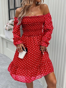 Detail of red off-shoulder polka dot dress featuring shirred bodice and ruffled hem