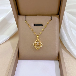 Elegant gold clover necklace with dancing crystals in jewelry box for women
