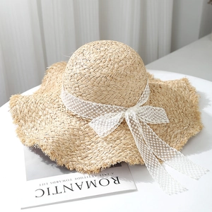 French raffia sun hat with wavy brim and white lace ribbon bow for beach vacations