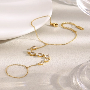 Détail d'une bague bracelet en or 18 carats avec zircons poire sur fond de scène texturé