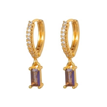 Detail of gold-plated earrings with pavé zircons and a rectangular purple gemstone