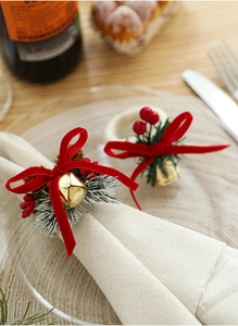 Detailed view of Christmas napkin rings with gold bells, pine cones and red berries