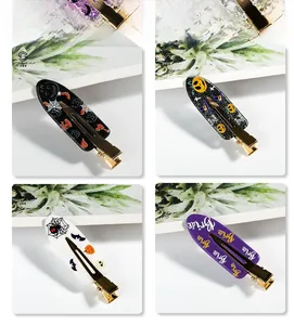 Detailed close-up of Halloween hair clips with spider web and Bride lettering patterns