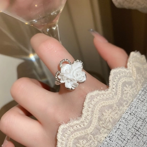 Close-up of white flower ring with silver band and zircon stone detail for women