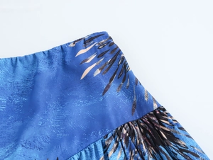 Detail view of elastic waistband and blue feather print texture on the long skirt