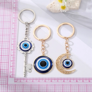 Detaillierter Vergleich von Evil-Eye-Schlüsselanhängern in Gold und Silber mit Maßstab