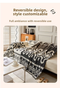 Close-up of bohemian chenille sofa cover with black and white geometric patterns and tassels