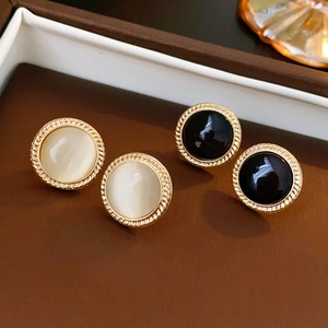Close-up of vintage round cat eye stone earrings with twisted gold metal frames