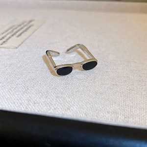 Macro view of a creative sunglasses-shaped open ring with black enamel lenses