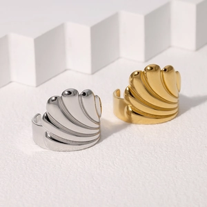 Minimalist shell-shaped stainless steel rings in gold and silver finish on white stone
