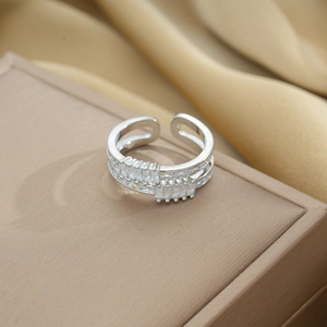 Detailed shot of silver double-layer ring with zircon on beige fabric box