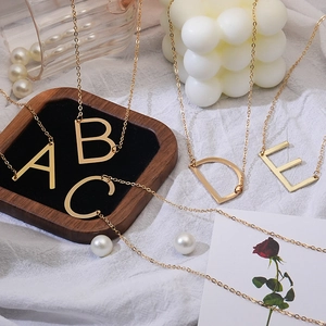 Elegant gold initial letter necklaces A to E with dainty chains on a stylish background