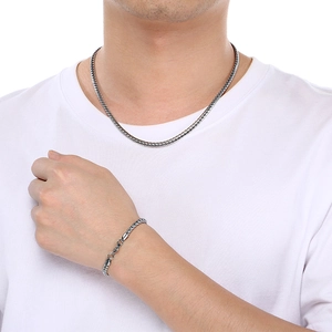 Stainless steel Franco chain necklace and bracelet set worn by male model on white background