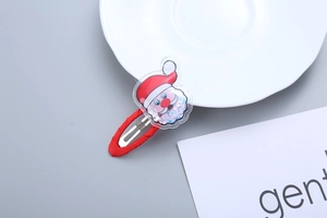 Detail of red Christmas hair clip featuring a Santa Claus head with moving sequins