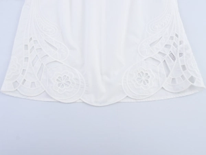 Gros plan détaillé sur la broderie anglaise blanche et l'ourlet festonné raffiné