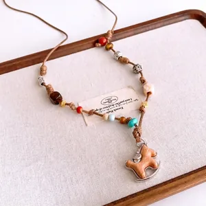 Handmade woven necklace featuring a wooden rocking horse pendant and marble beads