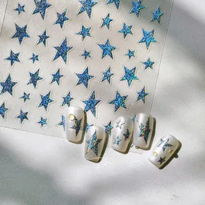 Detail of 3D silver star nail stickers with blue glitter on pearly white false nails