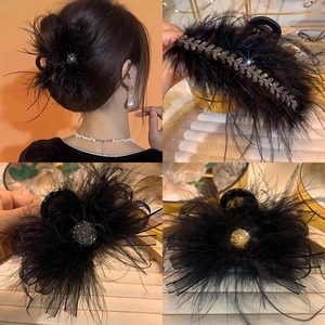 Elegant black feather hair claw clip with rhinestones and golden accents for women