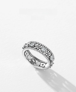 Macro detail of S925 sterling silver daisy ring with pavé diamonds and floral hollow work