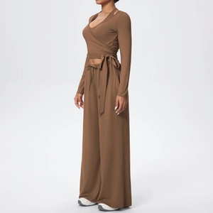 Détail du haut cache-cœur marron avec nœud latéral et pantalon large taille haute