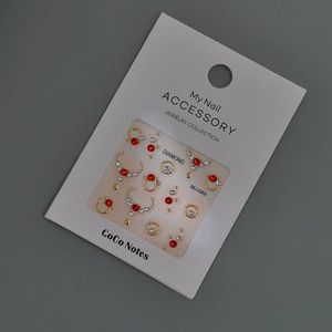 Golden nail art jewels set with red water drop rhinestones on white display card