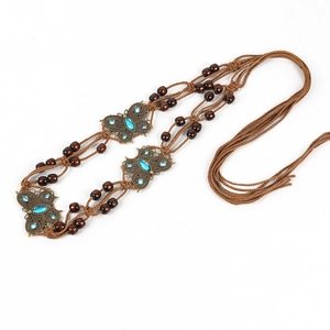 Detail of woven brown rope belt featuring bronze metal butterflies with blue rhinestones
