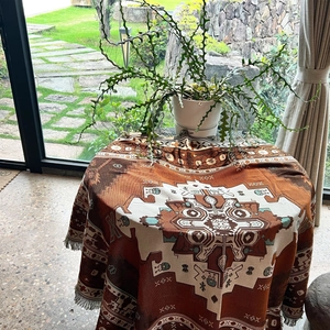 Close-up of Bohemian cotton blanket with geometric patterns and fringe edges on a table