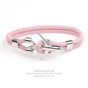 Pink braided Milan rope bracelet with a silver aircraft charm on a white background