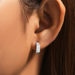 Close-up of 925 sterling silver C-shaped hoop earrings with sparkling paved zircons on model