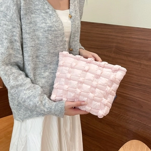 Detail of pink puffy cloud makeup bag featuring soft quilted texture and canvas fabric