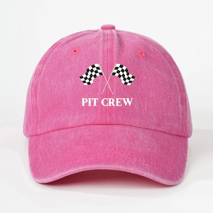 Close-up of pink cotton baseball cap featuring Pit Crew text and racing flags detail