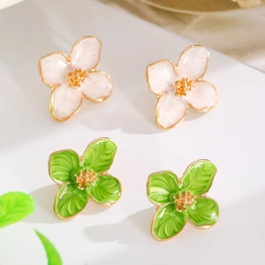 Detailed macro view of four-petal flower earrings with textured enamel finish and gold stamens