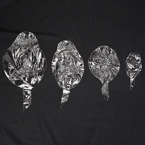 Set of four pre-stretched transparent round BOBO balloons in various sizes on black background