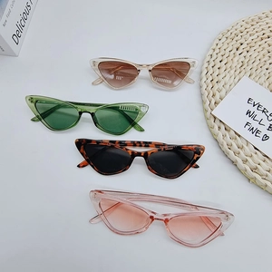 Close-up of stylish triangle cat-eye sunglasses in champagne, green, tortoiseshell, and pink