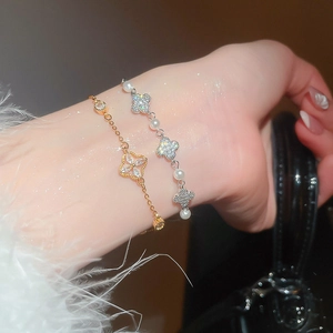 Close-up of elegant clover bracelet featuring pearls and zircon on model's wrist