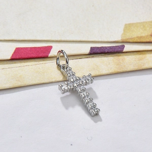 Silver cross pendant with sparkling clear cubic zirconia stones on geometric backdrop