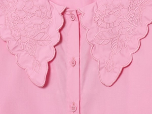 Close-up of pink long-sleeve shirt featuring delicate floral embroidery and hollow-out collar