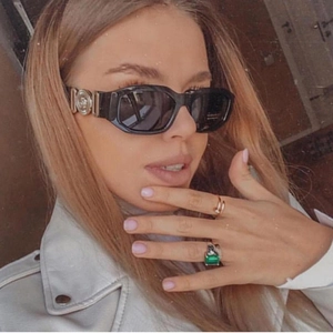 Fashionable black square sunglasses with gold logo detail and elegant emerald ring set
