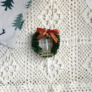Détail d'un décor de gâteau couronne de Noël avec nœud rouge et cloches dorées sur dentelle