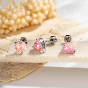 Pink heart-cut zircon stud earrings with silver four-claw setting on velvet display