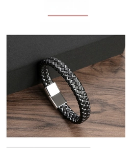Detailed macro view of men's braided leather bracelet with silver magnetic metal clasp