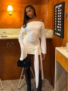 Détail d'une robe courte blanche à épaules dénudées avec nœud et tissu drapé