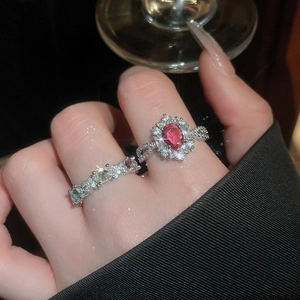 Detailed view of luxury oval red zircon ring and colorful gemstone band on hand