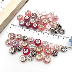 Flat lay of pink large hole charms for DIY bracelets with ruler showing bead size detail