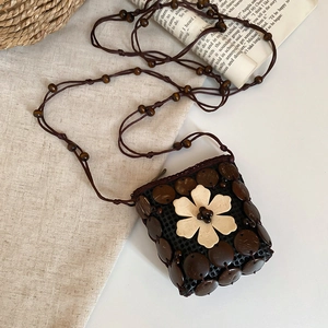 Detail of bohemian coconut shell cross body bag with resin flower and wooden beads