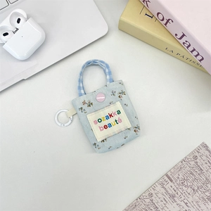 Close-up of floral mini storage pouch with blue handles and pink button detail