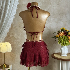 Rear view of dark red lace bikini top and matching layered skirt on a display mannequin